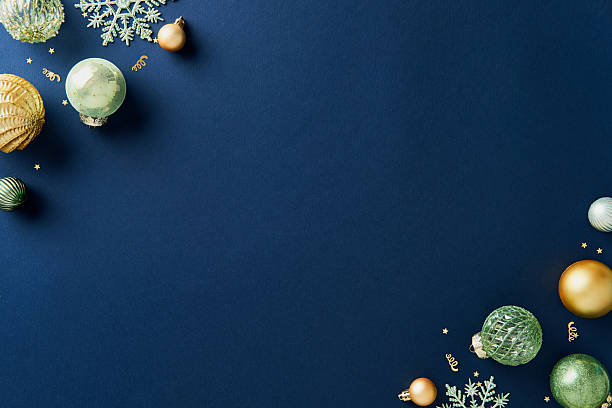 istock Corner Christmas composition with shiny gold and green Xmas decorations on navy blue background. Flat lay, top view, copy space. 2247293384