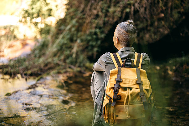 istock Woman relaxing by a waterfall in nature 2247296027