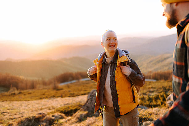 istock Couple hiking uphill together during sunset 2247296189