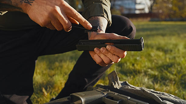 Senior man cleaning his weapon at home