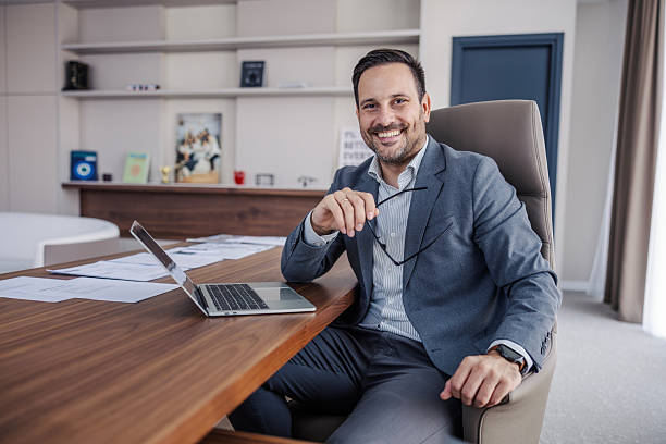 istock Confident businessman smiling sitting at office desk 2247299463