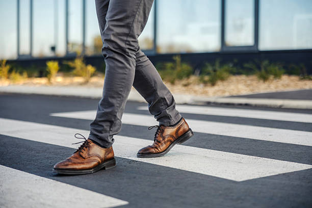 istock Person walking on crosswalk in city street 2247299523