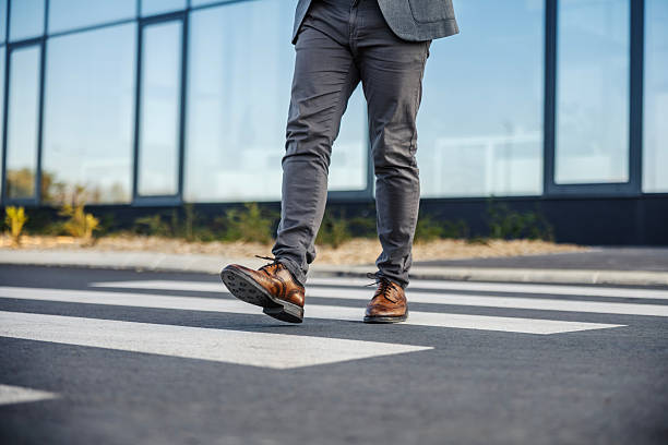 istock Business man walking across urban street crosswalk 2247299533