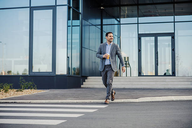 istock Businessman enjoying refreshing drink walking across city street 2247299535