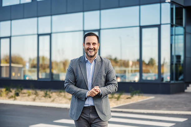 istock Confident businessman smiling outdoors in front of office building 2247299582
