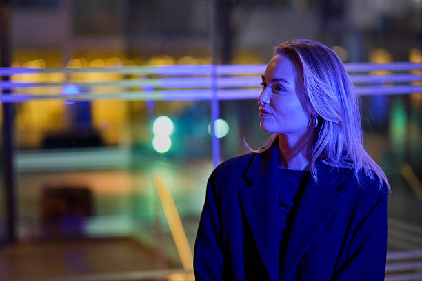Portrait outdoors of young blond woman 24 years old in twilight, Blue light strikes the woman