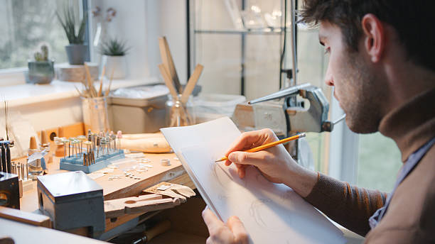 istock Male Jeweller At Workbench Sketching Out Design For Ring In Studio 2247301833