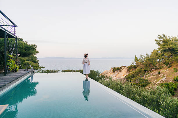 istock Woman walking along the edge of the infinity pool 2247303324