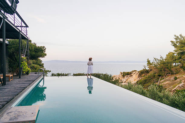 istock Woman walking along the edge of the infinity pool 2247303345
