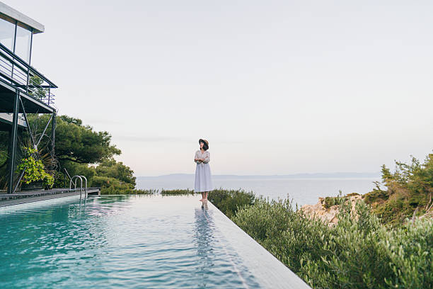 istock Woman walking along the edge of the infinity pool 2247303356