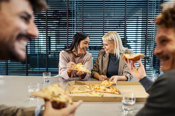istock Business colleagues sharing pizza lunch creating team connection 2247304175