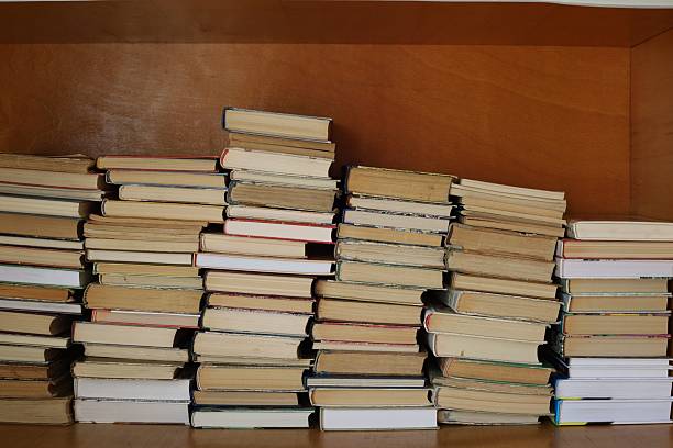 istock Stacked books in an organized wooden shelf 2247305427