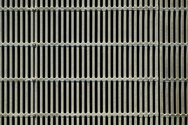 A grid-patterned roadside ditch cover with a regular pattern.