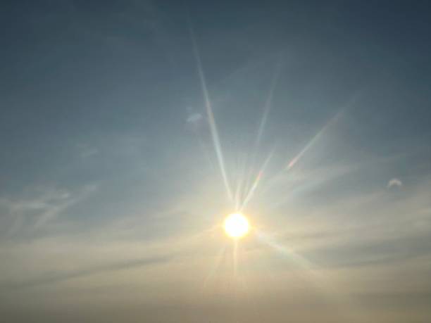 istock Bright Sun Shining Through Clear Blue Sky with Subtle Clouds and Lens Flare Effects in a Serene Landscape Atmosphere 2247306152