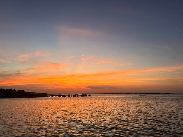 istock Serene Sunset Over Tranquil Waters with Silhouetted Dock and Vibrant Sky in Evening Glow 2247306508