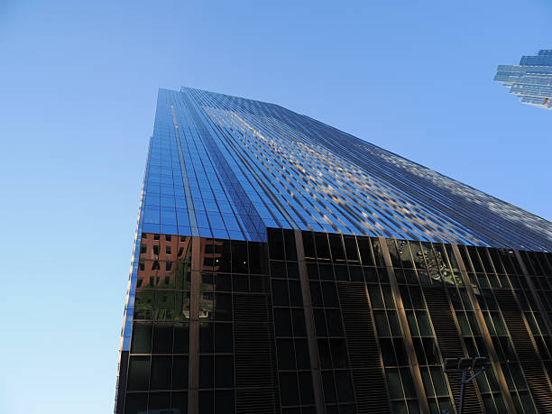 Chicago, IL - September 15, 2025: Extreme low angle of a contemporary glass and black facade skyscraper reflecting the cityscape.
