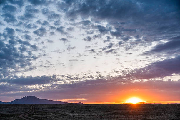istock The sun sets over a desert landscape with mountains behind it 2247309644