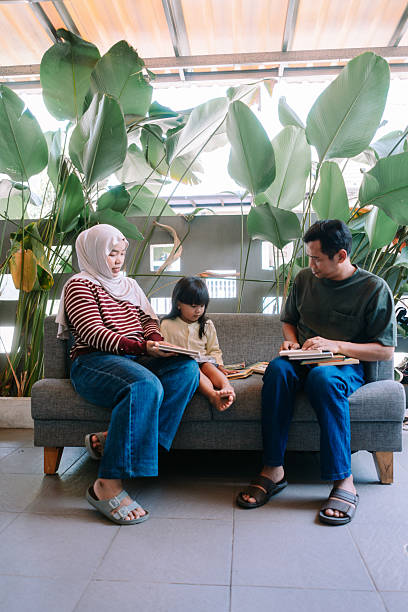 istock Family Reading Books Together in a Relaxing Home Setting 2247310859
