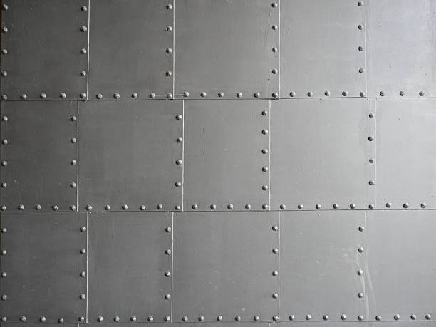 istock Old metal door with riveted plates and gray surface in shaded light gradient 2247315683