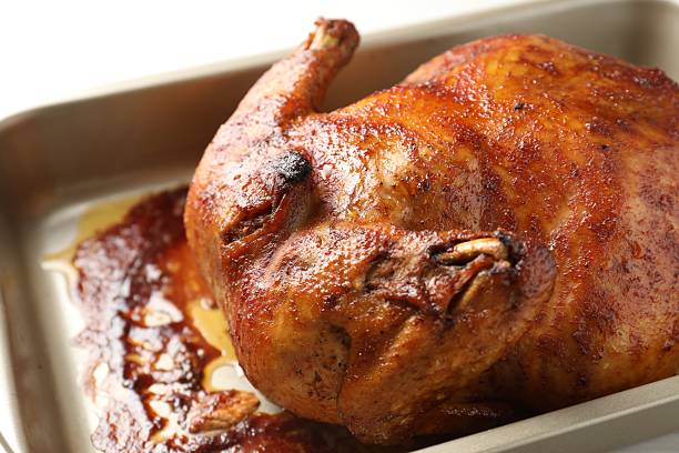 istock Delicious baked turkey in baking dish on light table, closeup 2247315776