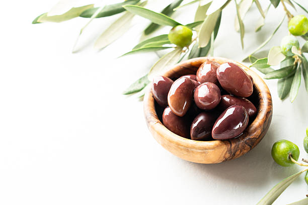 istock Olives in the bowl at white table. 2247316682