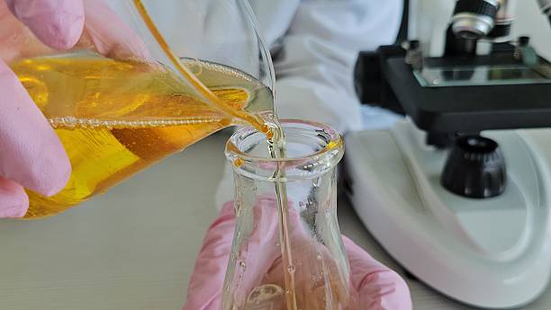 istock Scientist chemist pouring liquid into flask with motor oil in laboratory closeup. Quality control of petroleum products concept 2247316708