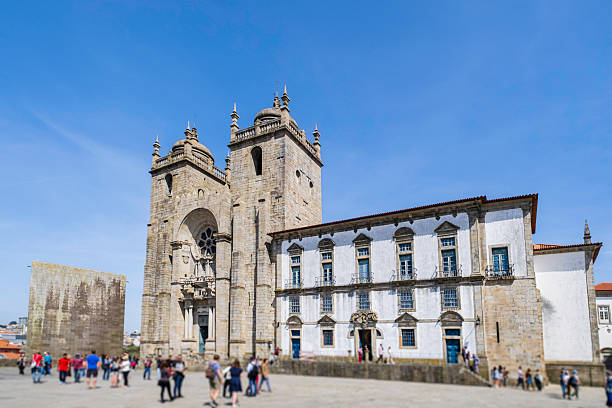 Tourists strolling in front of the imposing Porto Cathedral, dating back to the 12th century, with a baroque style that was given to it in the 17th and 18th centuries: the portal still conserves the medieval rose window.