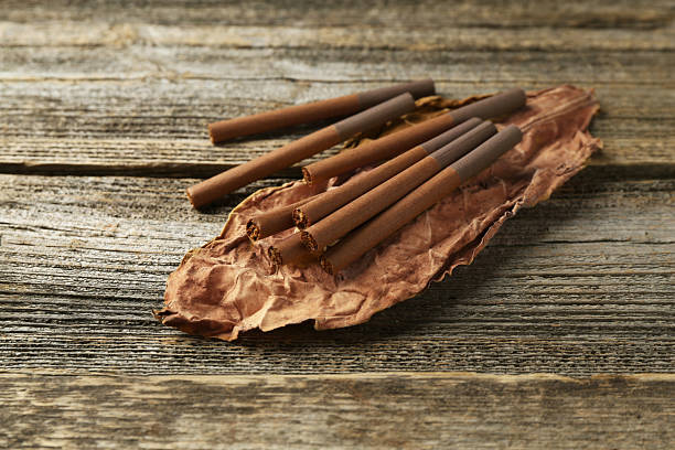 istock Dried tobacco leaf and cigarettes on wooden table, closeup 2247320180