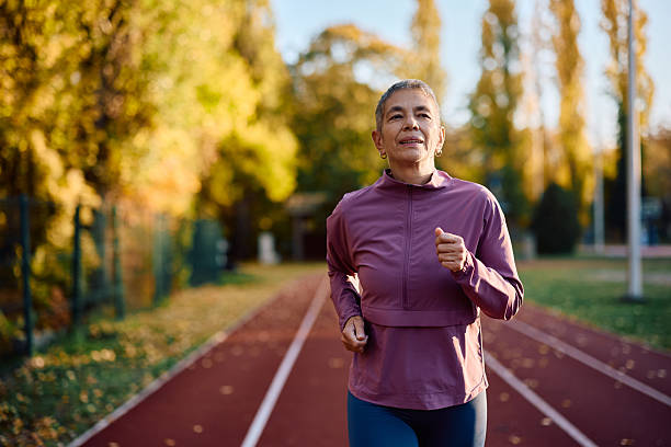 istock Mature female runner jogging in autumn park. 2247321334