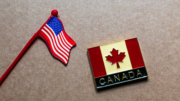 istock American and Canadian Flags isolated on plain light background, top view. 2247326026