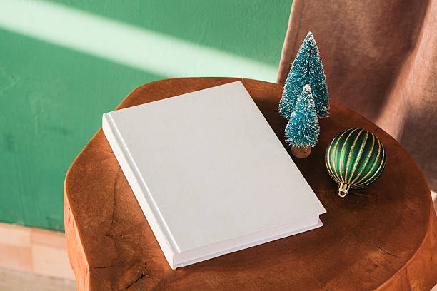 istock Blank book mockups with Christmas and New Year decorations on table with shadow 2247330431