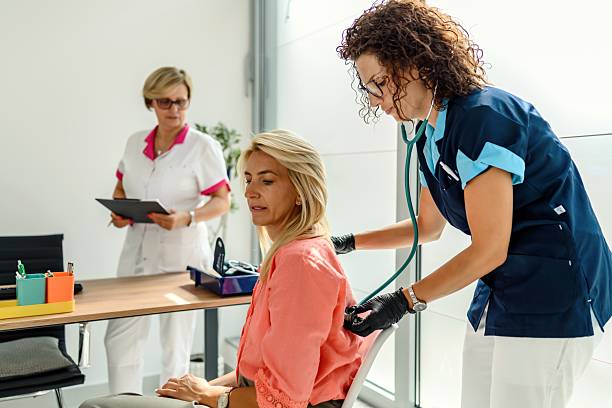 istock Female doctor using a stethoscope on a patient's chest at a medical 2247330601