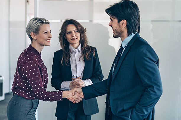 istock Business persons shaking hands in modern office space 2247332303