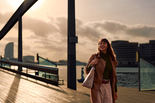 istock Happy woman walking city bridge at sunset 2247332504