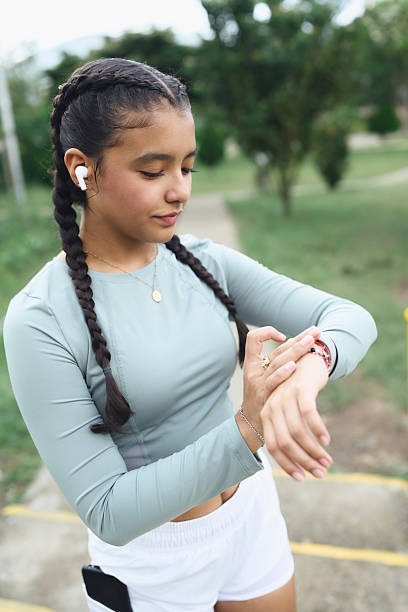 istock Young woman checking fitness tracker during outdoor exercise 2247334455
