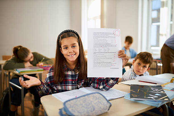 istock Schoolgirl showing her C grade on a test at elementary school 2247334718