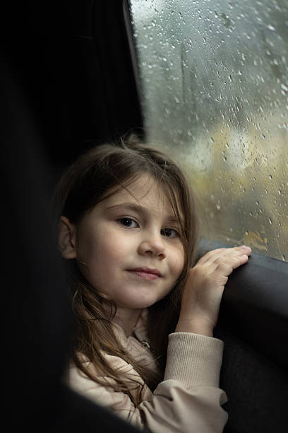 istock Little girl looking out from car window 2247336520