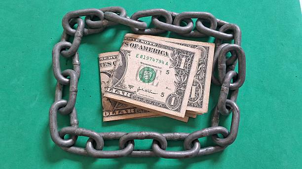 istock Dollar bills surrounded by a steel chain 2247338085