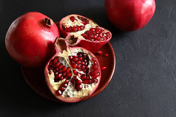 istock Fresh ripe pomegranate isolated on a black background. 2247338634