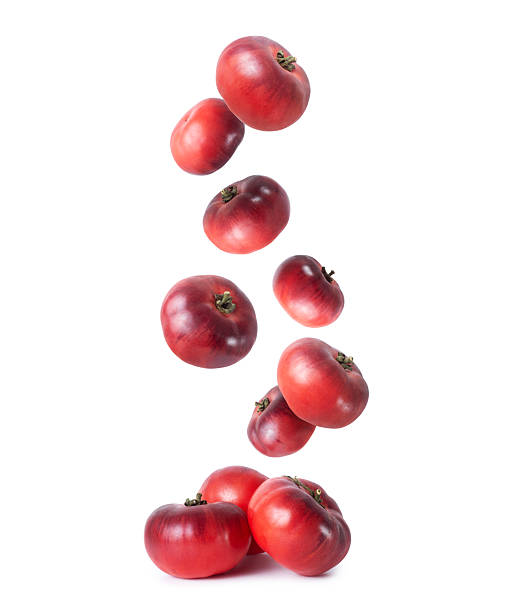 istock Organic dark red tomatoes falling down close up on a white background 2247340048