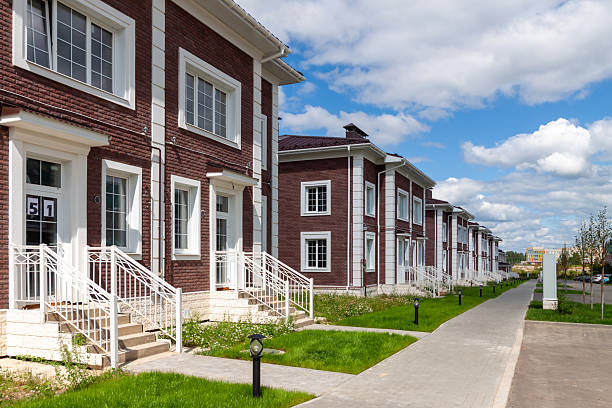 Row of modern brick townhouses with white architectural accents in a newly developed residential neighborhood.
