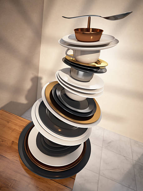 Tall tower of stacked plates and cups sits on a wooden table, showcasing a mix of colors and shapes. The arrangement captures attention with its unique balance and artistic flair.