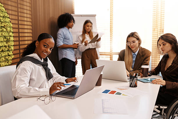 istock Inclusive team working at office table, woman in wheelchair using digital tablet 2247343974
