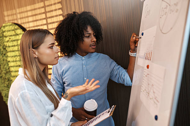 istock Coworkers discussing data charts on flipchart in modern office 2247343985