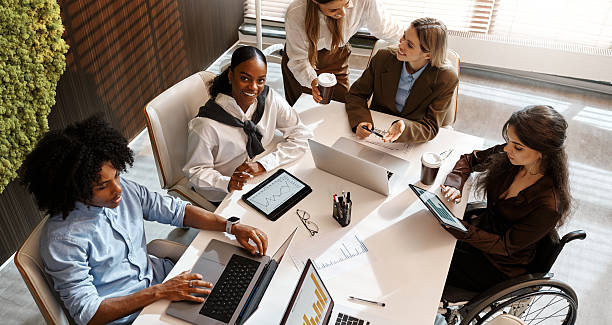 istock Diverse business team analyzing charts during office meeting from top view 2247344068