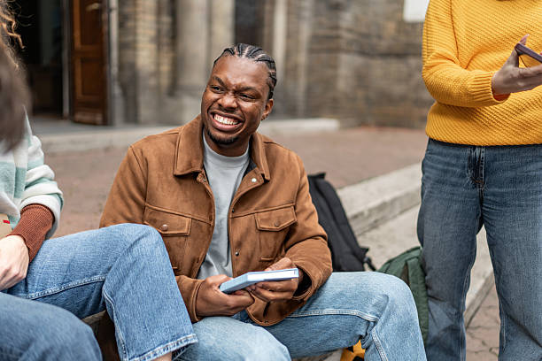 istock Young black man grimacing with friends at university 2247346652