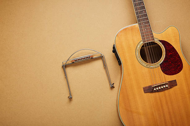 istock Acoustic guitar and an harmonica on its neck holder 2247346730
