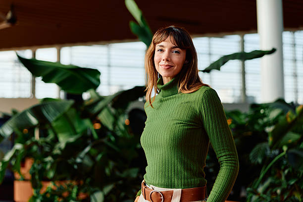 istock Woman smiling in green turtleneck surrounded by plants 2247347263