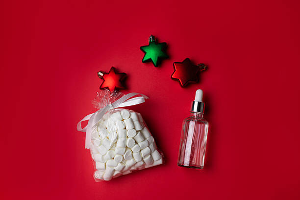 istock Christmas star decorations, marshmallow bag and cosmetic serum on red background 2247347975