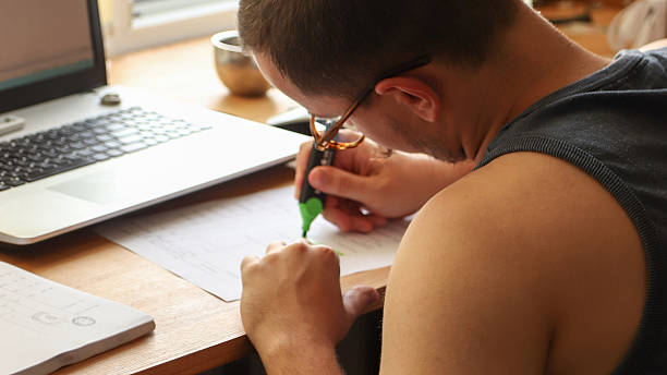 istock a man at a desk, using a marker to check items off a to do list, checklist. The setting is clean with a hint of green, symbolizing efficiency, organization, and the completion of tasks 2247348182